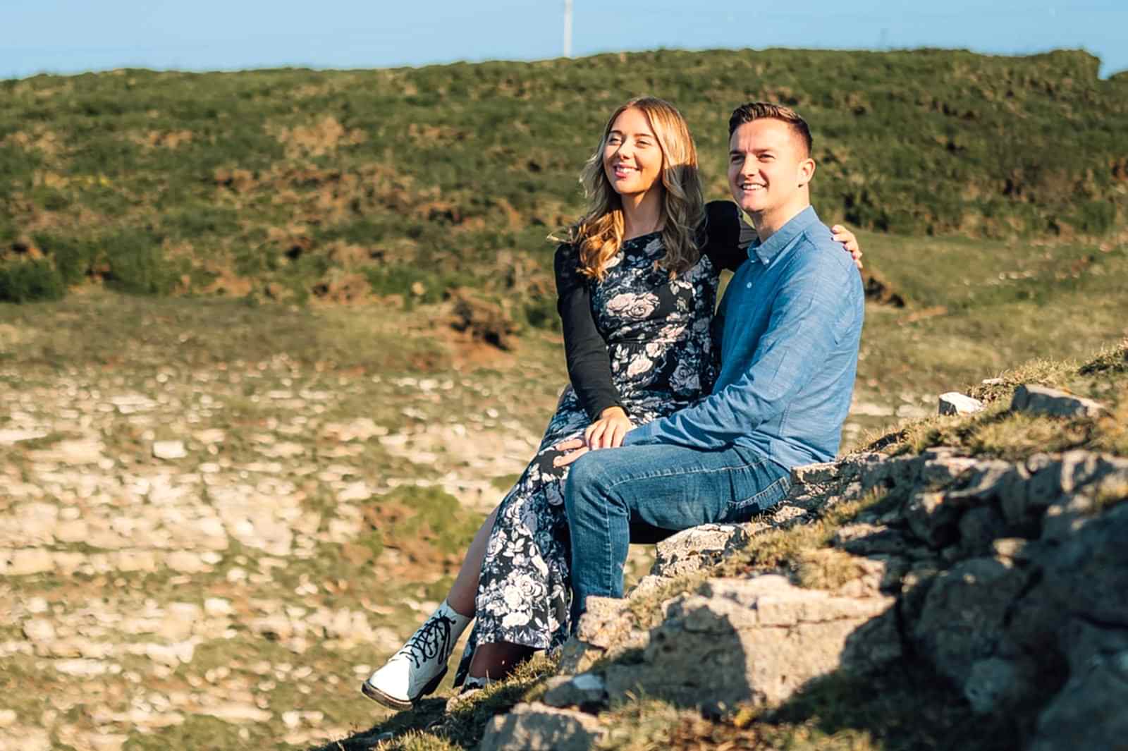 amy & Nath sat on a rock holding hands